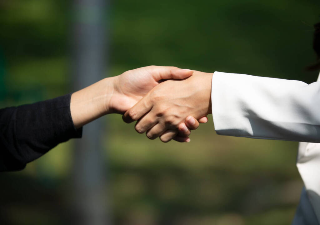 Business people shaking hands, finishing up a papers signing. Meeting, contract and lawyer consulting concept.